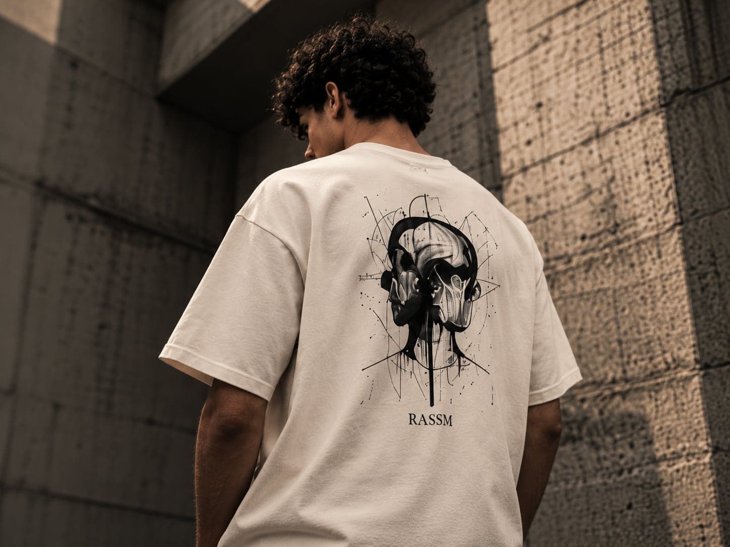 Jeune homme de dos en t-shirt RASSM crème, imprimé croquis dans le dos